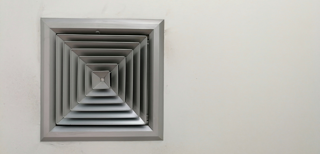 Square ceiling air conditioning vent installed in a residential interior